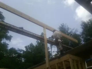 Carpenter setting a ridge beam over a new addition frame — Ice Dam Removal by Roofing Brothers in Deal